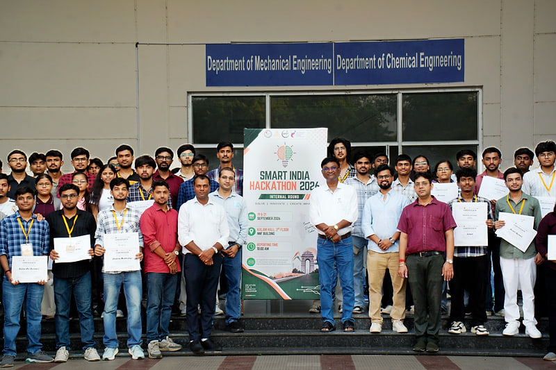 Participating teams, faculty and jury members gathered with their certificates outside the NNF Building at IET Lucknow, beside the Smart India Hackathon 2026 banner.
