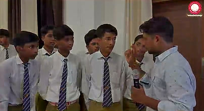 Students standing at the front of the hall in conversation with the speaker during the question round.